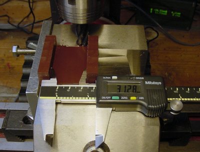 Checking the dimensions of the workpiece with a digital caliper before removing the workpiece from the milling machine vise.