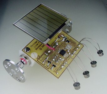 Chicago solar-powered miniature line-following robot with Miller solar engine, surface-mount Sandwich circuit, aluminum wheels, and sealed photocell sensors.