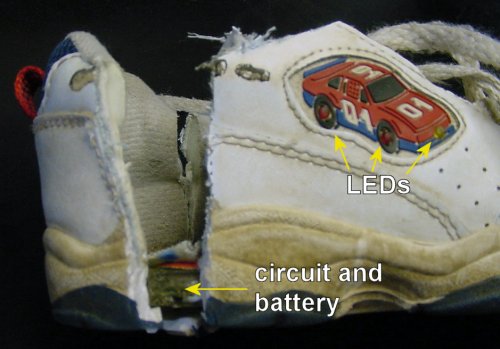 Light-up shoe with LEDs is cut open to reveal a circuit in the heel of the sole