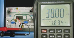 Infrared obstacle detector circuit implemented on a solderless breadboard and tuned using a multimeter with frequency display.