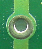 Hole with circle covered by solder mask.