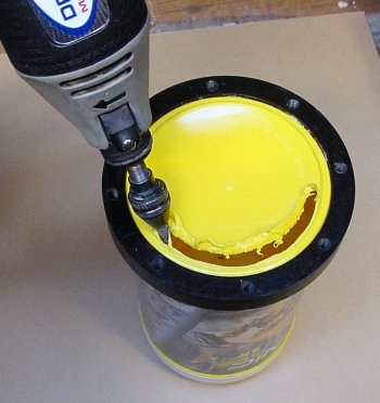 Grinding off the end of the yellow plastic canister.