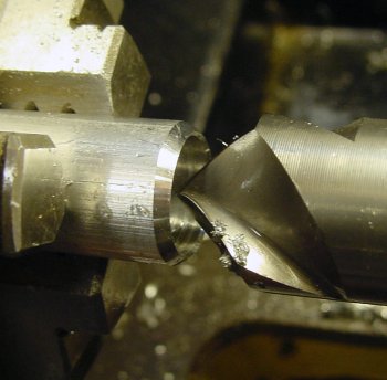 Deburring and chamfering a hole at the end of a rod using a larger diameter drill.